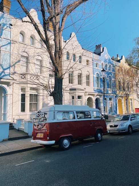 A white van is parked on the side of a two-lane road during the late afternoon or early evening, with a backdrop of rolling hills and scattered trees beneath a sky with soft, warm-colored clouds. The